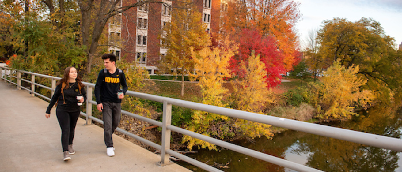 Two Students on Campus Bridge in the Fall. 