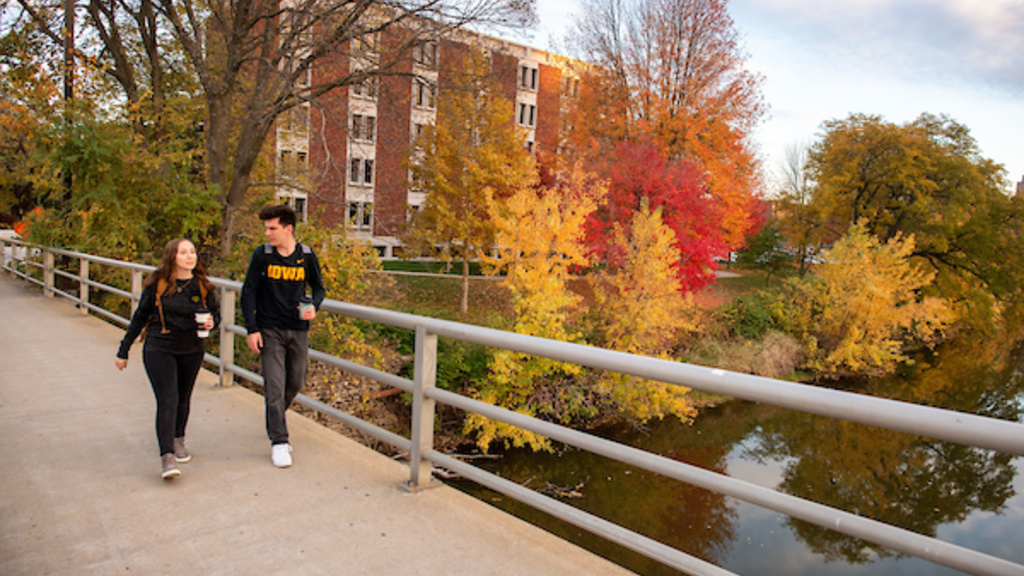 Two Students on Campus Bridge in the Fall. 